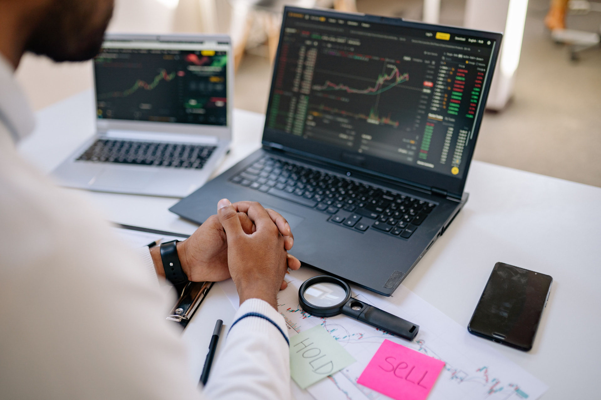 Trader reviewing positions across multiple screens
